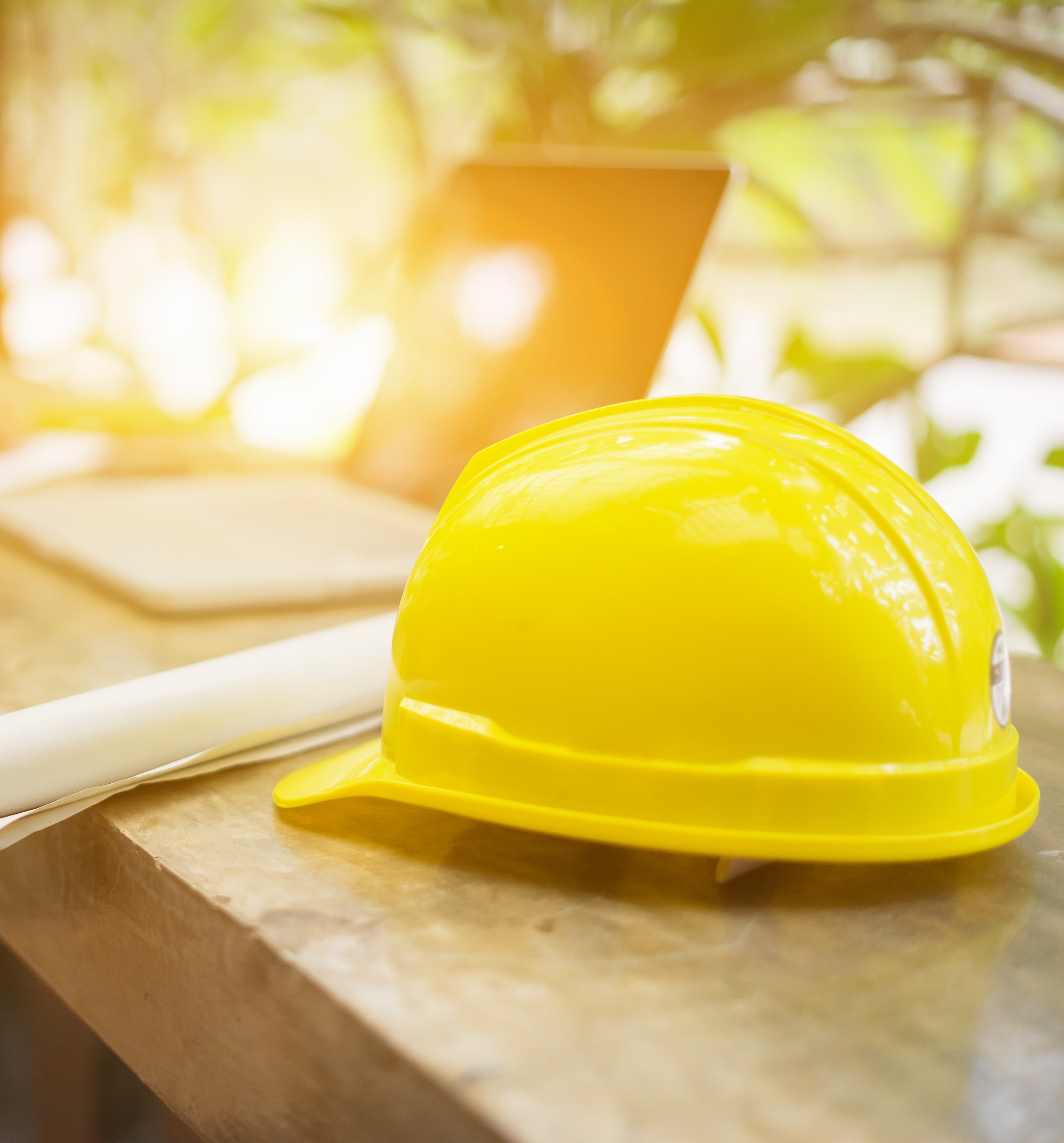 yellow hard safety helmet hat for safety project of workman as engineer  on work place, architect man working with laptop on background,construction project ,Business concept